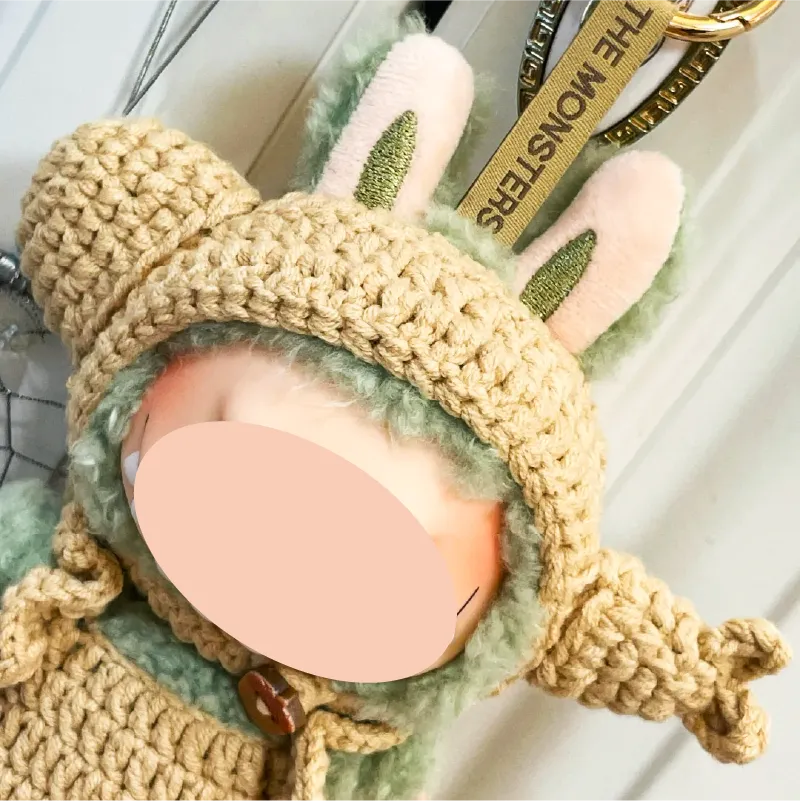 Handcrafted crochet doll wearing a beige knitted bear hoodie with bunny ears keychain