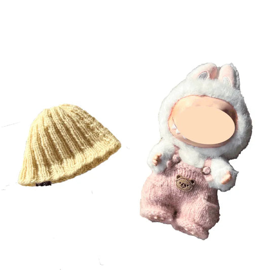 Knitted yellow beanie and pink bunny-shaped compact mirror on a white background