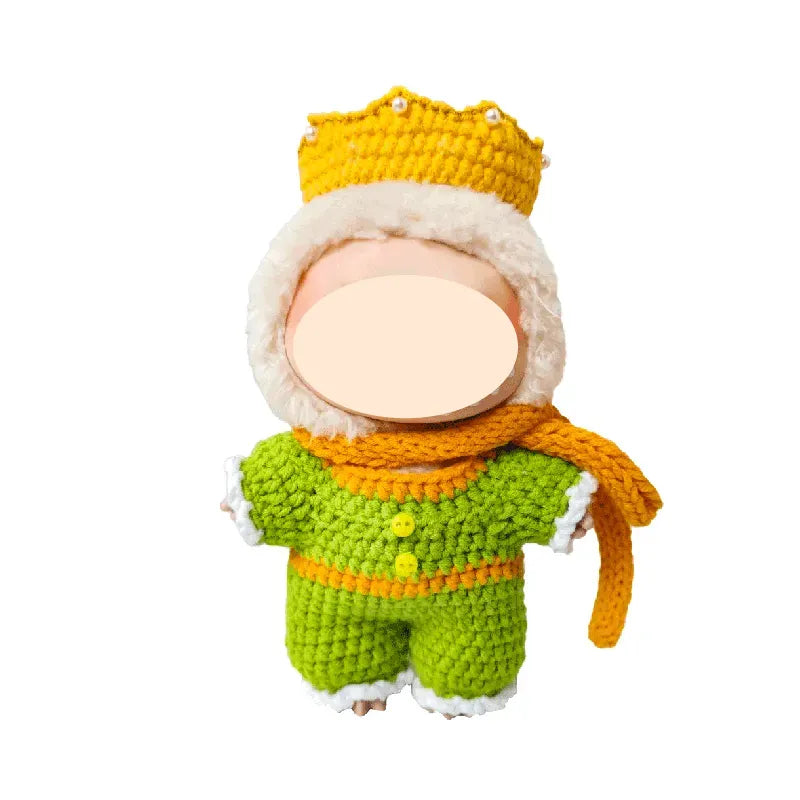 Knitted toy with a green outfit, orange scarf, and yellow hat on a white background
