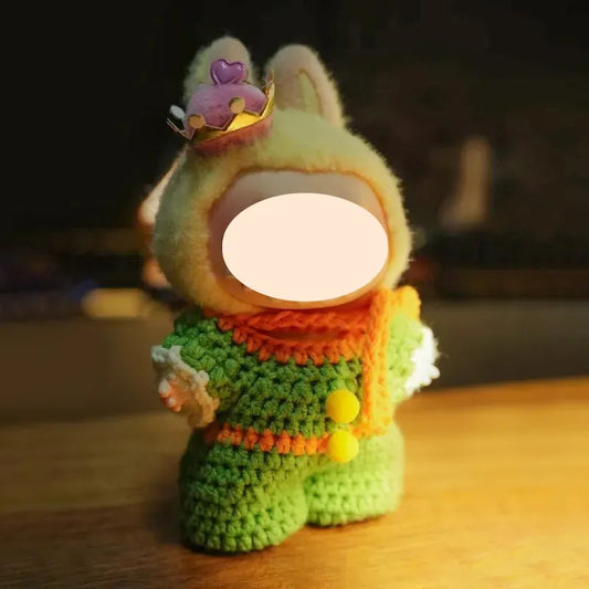 Crocheted toy with a round face on a wooden surface