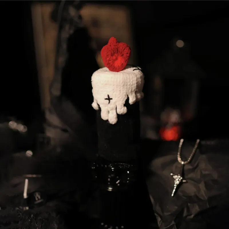 White hand-shaped object with a red heart on top, worn by a person in a dark setting.