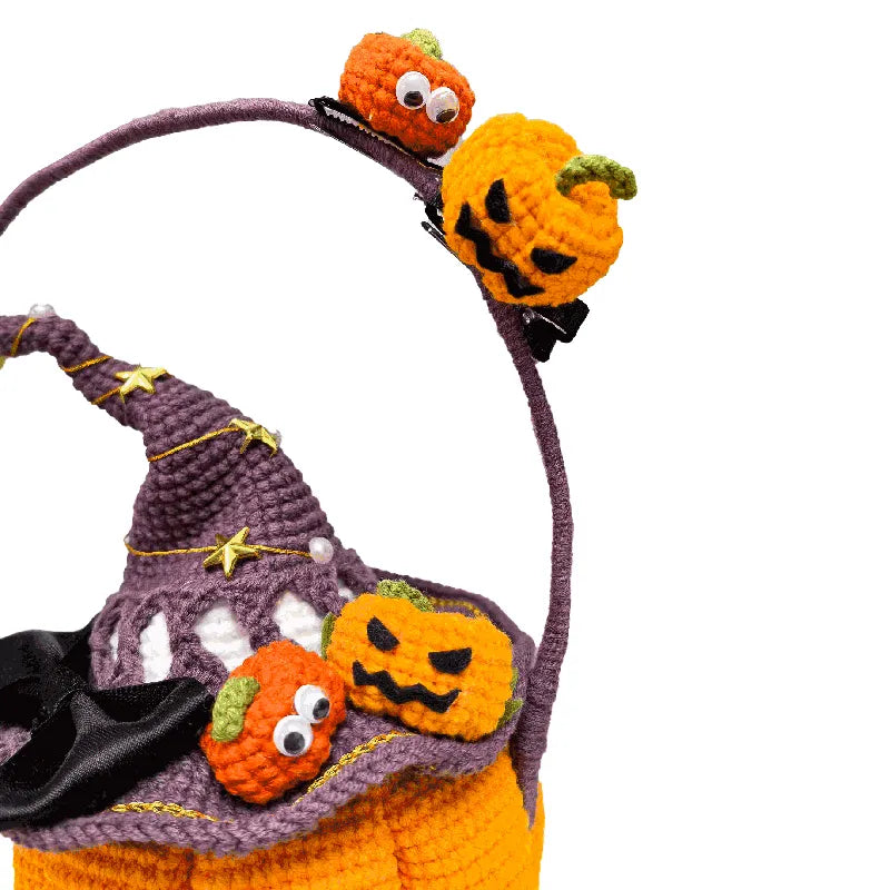 Crocheted Halloween basket with pumpkins and a witch hat on a white background
