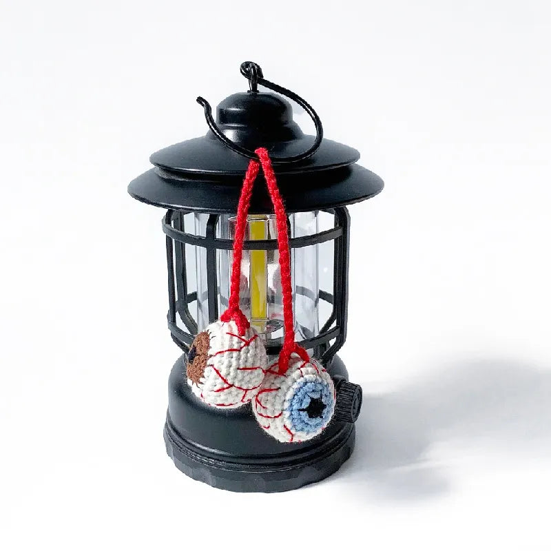 Black lantern with colorful hanging decorations on a white background