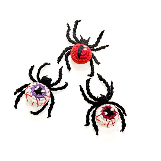 Three spider-shaped toys with colorful centers on a white background