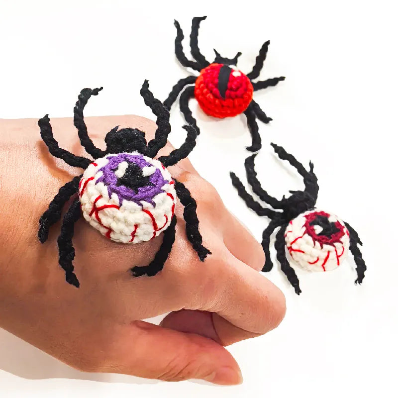 Spider-shaped rings with colorful designs on a white background