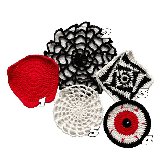 Collection of various crocheted items including a red heart, black and white flower, white doily, and black and white circular design on a white background.