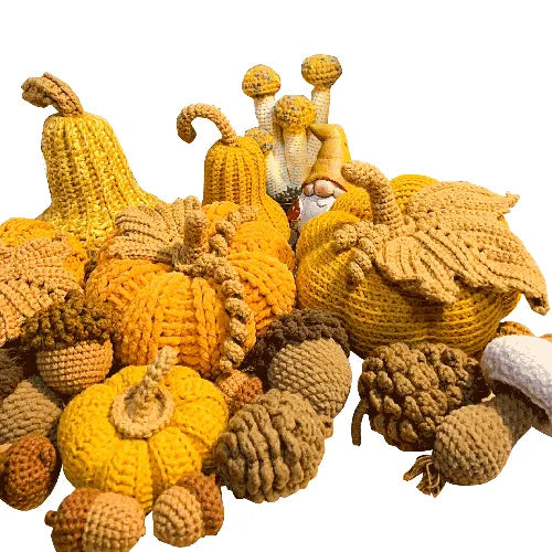 Collection of knitted pumpkins and a gnome on a white background