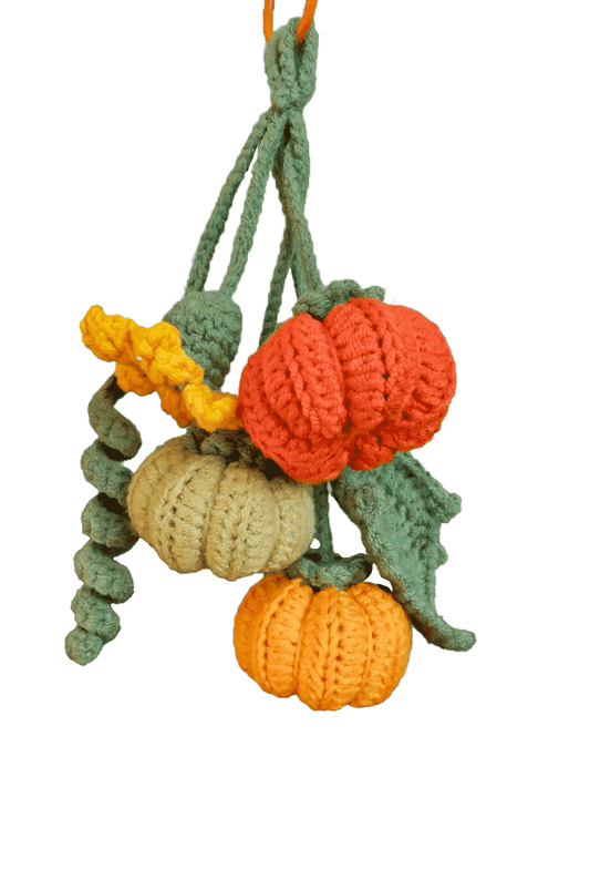 Crocheted pumpkins and leaves on a white background