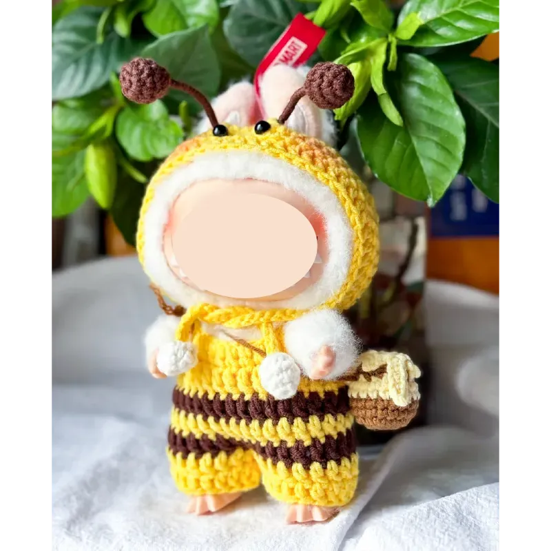 Bee crochet doll clothes pattern featuring a handmade yellow and brown striped outfit with antennae and a small basket accessory