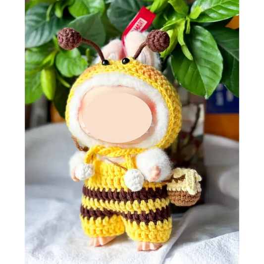 Bee crochet doll clothes pattern featuring a handmade yellow and brown striped outfit with antennae and a small basket accessory
