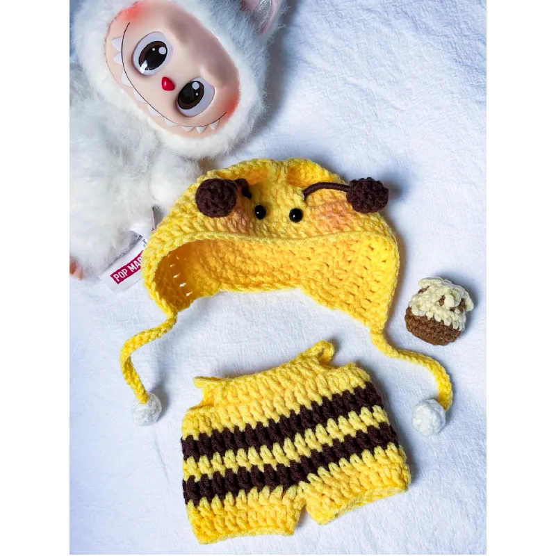 Bee crochet doll clothes pattern featuring yellow and brown striped shorts and a hat with antennae