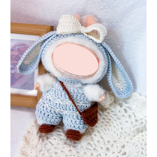 Bunny crochet doll wearing handmade blue overalls and cream bow using bunny crochet doll clothes pattern