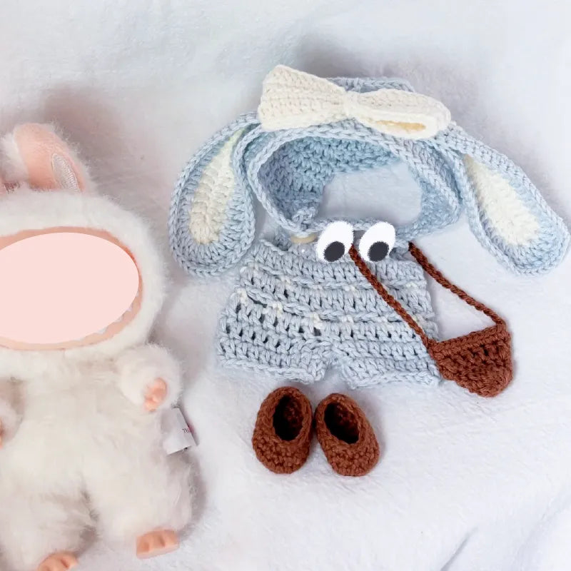 Bunny crochet doll clothes pattern featuring blue shorts, long ears headband, brown shoes, and a small purse