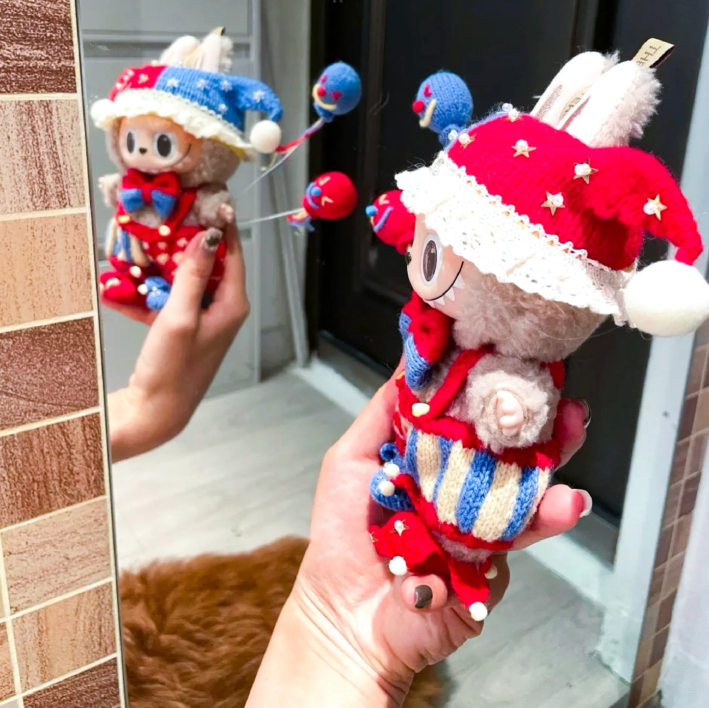 Circus Clown Crochet Pattern plush toy with red and blue hat and colorful stitched details held in hand