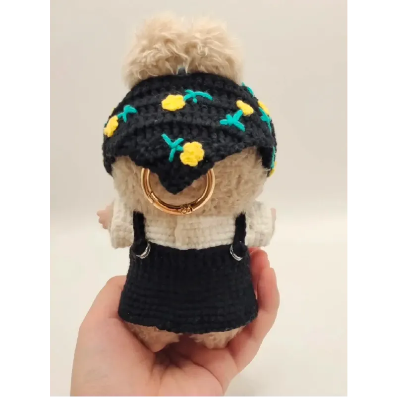 Collectible doll crochet outfit featuring a black skirt and floral headband with yellow flowers