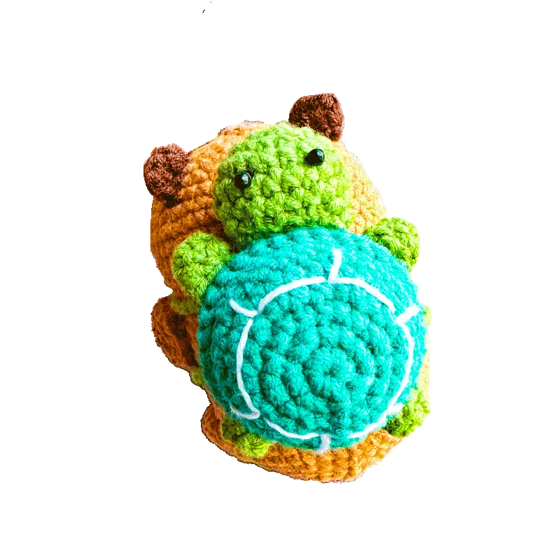 Handmade crochet capybara keychain pattern featuring a colorful green and orange stuffed animal with a blue shell