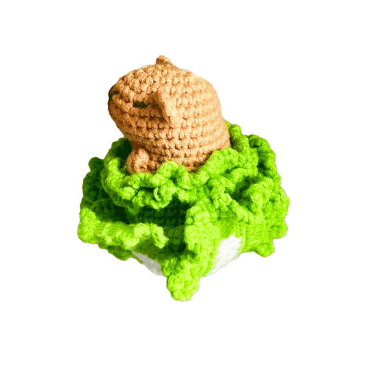 Handmade crochet capybara pattern featuring a light brown capybara resting on bright green textured yarn