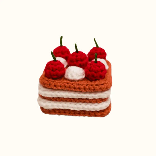 Crochet cherry cake pattern from The Knit Krazy showing a layered cake with red cherries and white cream