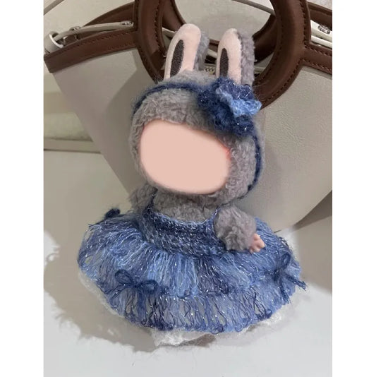 Handmade crochet doll wearing a blue and gray outfit featuring a crochet doll dress pattern with bunny ears and flower detail