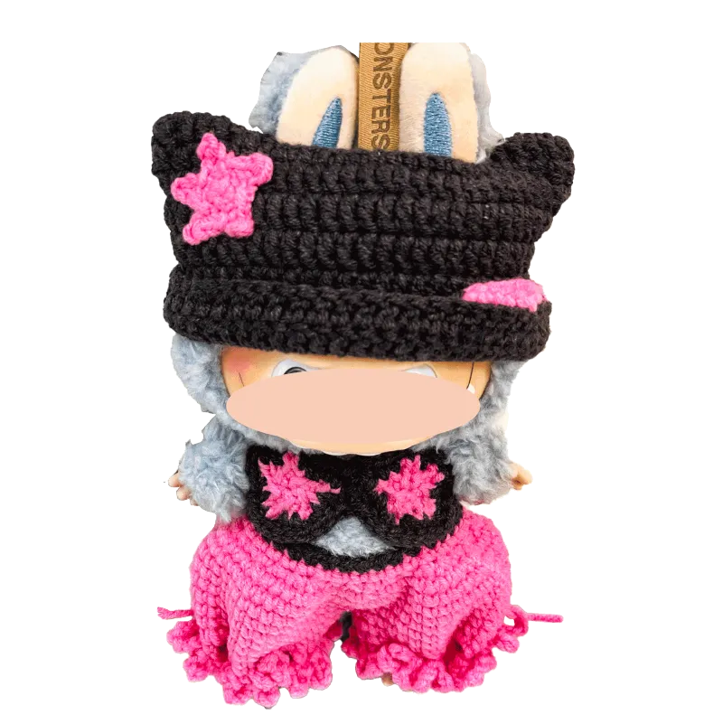 Handcrafted crochet doll wearing a black hat with pink stars and matching pink pants by The Knit Krazy