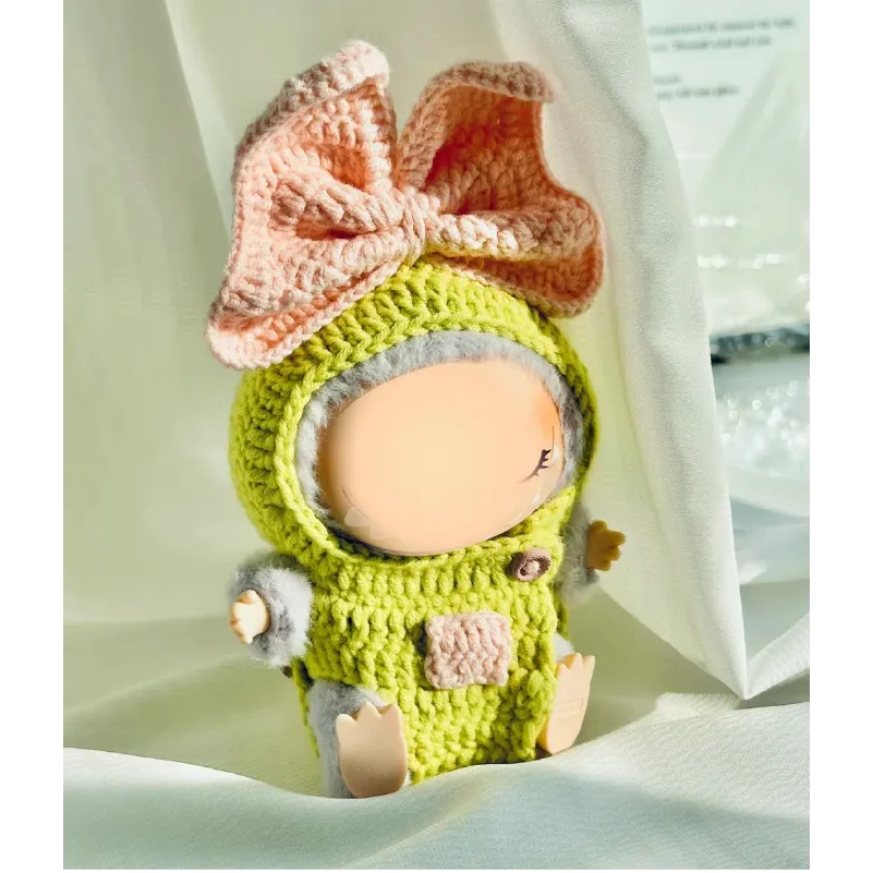 Cute crochet doll dressed in a green and pink crochet doll outfit pattern with a large bow