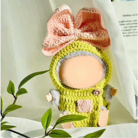 Handmade crochet doll wearing a green and pink crochet doll outfit pattern with large bow