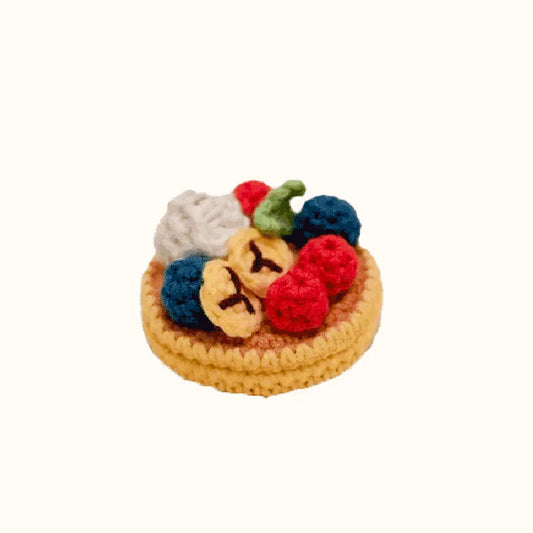 Crochet fruit pancake pattern featuring colorful crocheted berries and bananas on a small pancake base