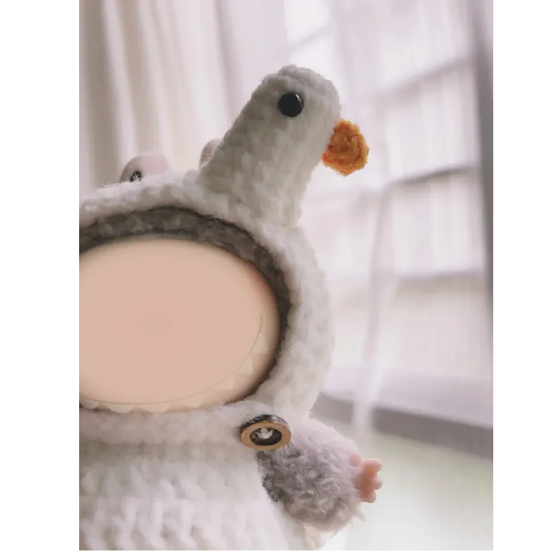 Close-up of handmade crochet goose outfit pattern on a doll with detailed beak and eyes