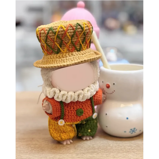 Crochet little duke outfit pattern featuring a doll with a colorful hat and ruffled collar next to a snowman mug