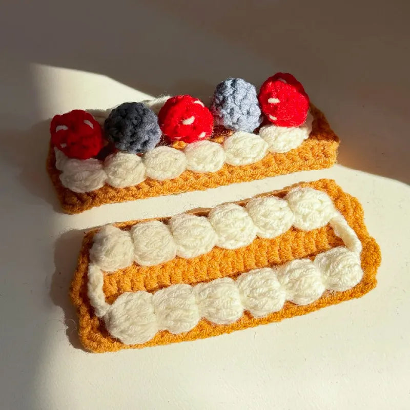 Handcrafted crochet Napoleon cake pattern featuring layered cream and berry decorations in vibrant colors