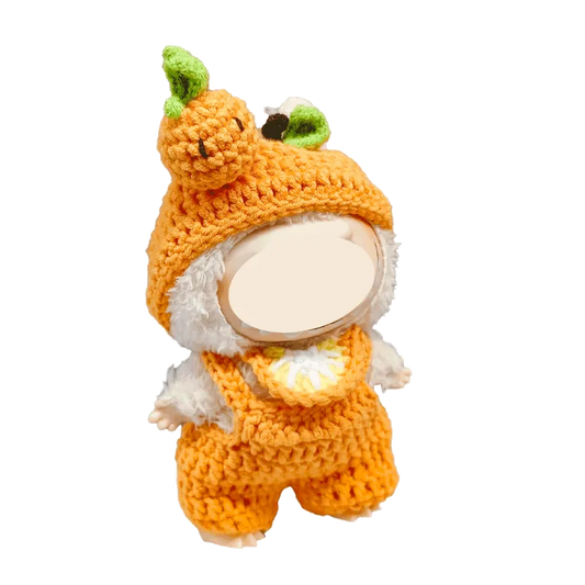 Crochet orange plush outfit pattern on a small stuffed toy with pumpkin hat and overalls