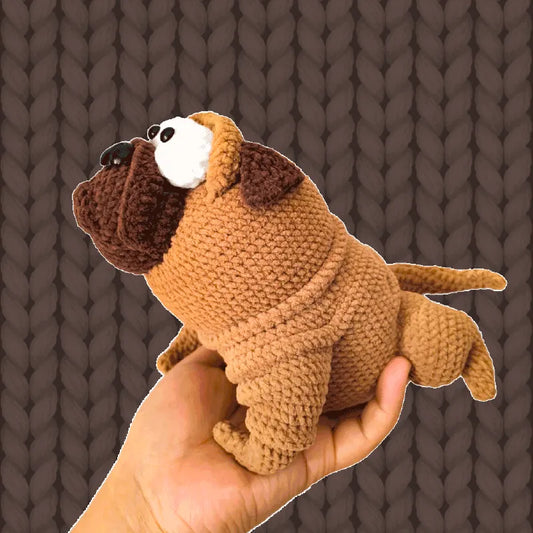 Hand holding a handmade crochet pug doll created using crochet pug doll pattern with detailed stitching