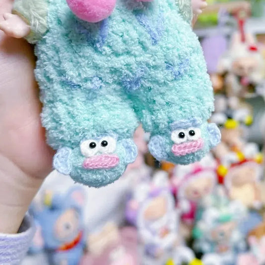 Close-up of DIY crochet shoes for 17cm plush in blue with cute monkey faces held by hand