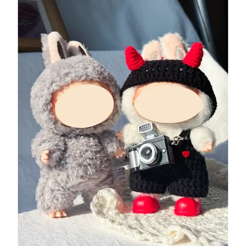Two plush dolls, one wearing a DIY crochet devil costume with red horns and black outfit holding a camera