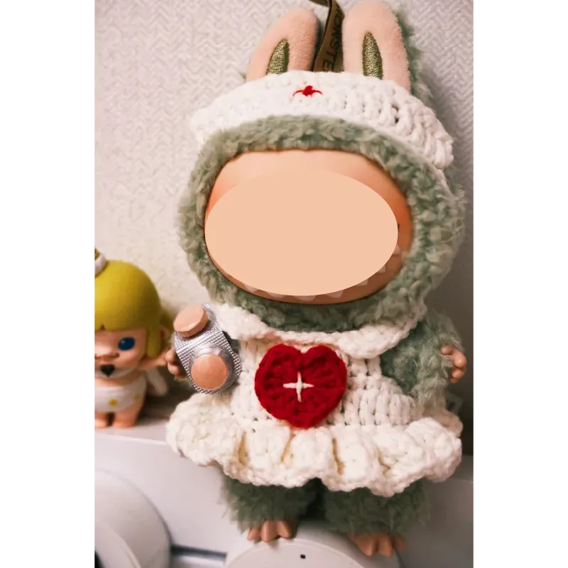 Cute doll wearing a handmade crochet outfit with a heart detail using free crochet nurse outfit pattern