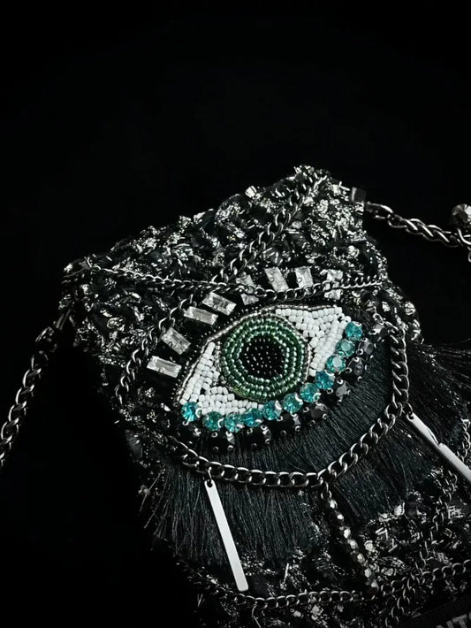 FREE|cyberpunk crochet phone bag pattern featuring an eye design with metallic chains and textured black yarn