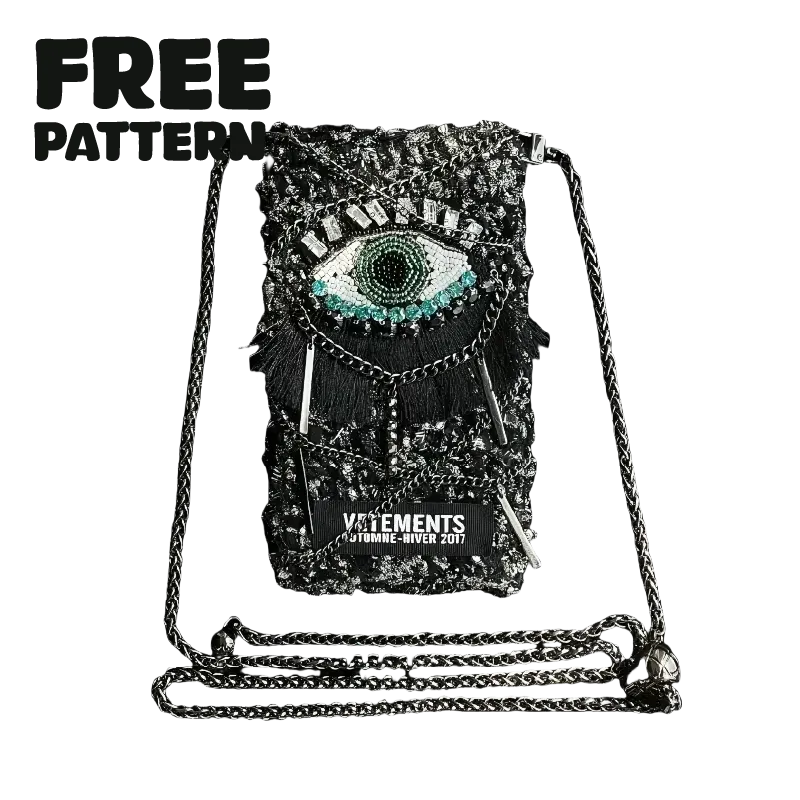 FREE|cyberpunk crochet phone bag pattern featuring a black crochet design with an eye motif and metallic chain strap