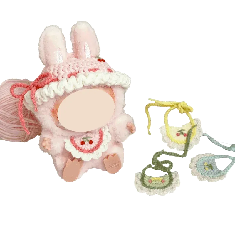 White crocheted plush toy hat with pearl beads and gold charm on red background free plush toy hat and bib crochet tutorial