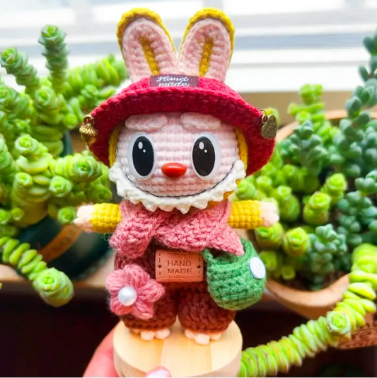Handmade crochet bunny doll wearing red hat and pink scarf by The Knit Krazy