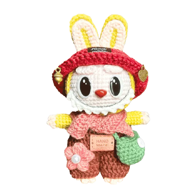 Handmade knitted bunny doll with red hat, pink scarf, green bag, and brown outfit by The Knit Krazy