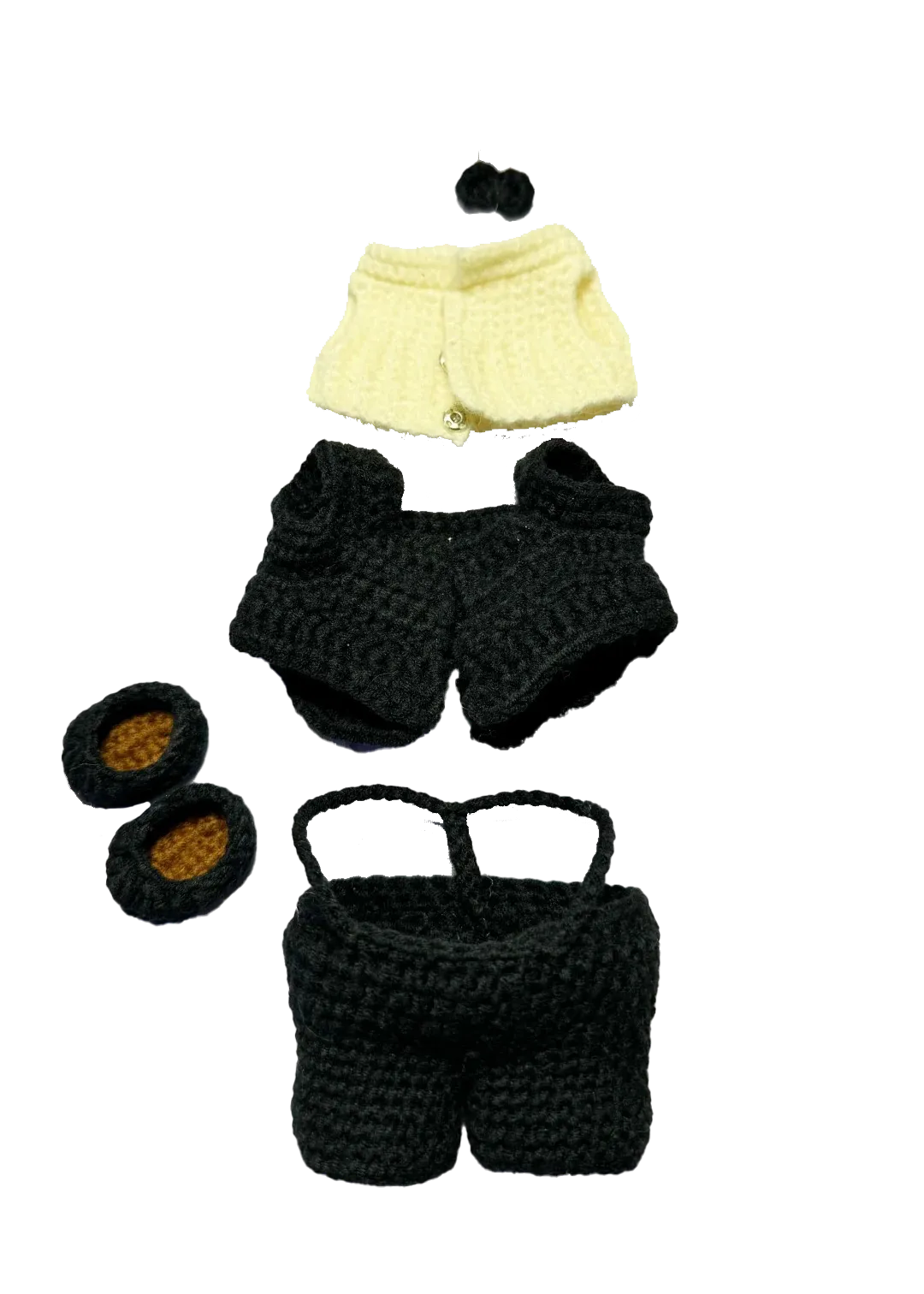 Handmade black and cream crochet doll wedding pattern clothing pieces on black background