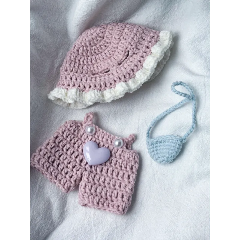 Pink knit doll outfit with a hat, shorts with heart decoration, and a small blue purse