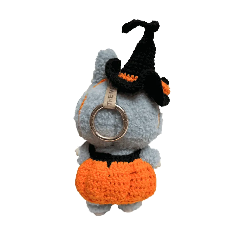 Cute doll wearing a handmade pumpkin costume pattern for dolls with an orange skirt and black witch hat