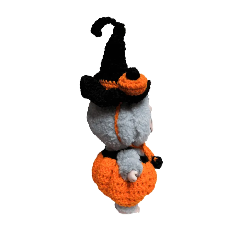 Handcrafted doll wearing a crocheted pumpkin costume pattern for dolls with a black witch hat