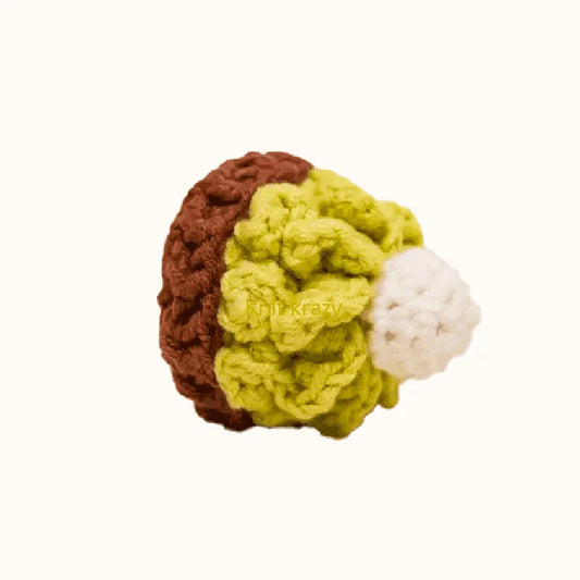 Crocheted matcha cake with brown base, green frosting, and white cream using crochet matcha cake pattern