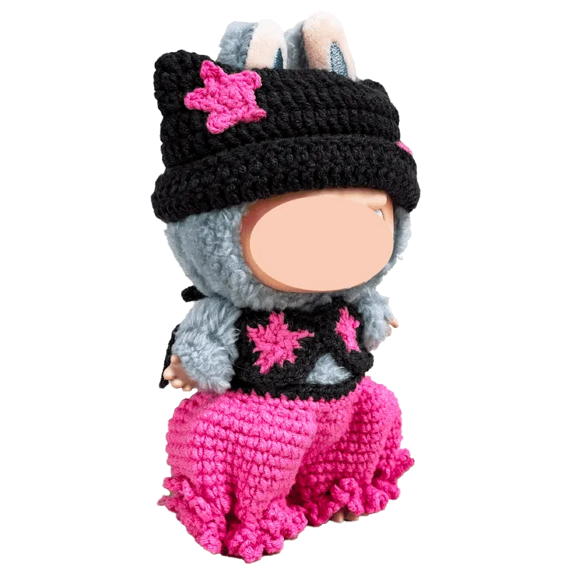 Handmade crocheted doll wearing pink pants and a black hat with pink star accents from The Knit Krazy