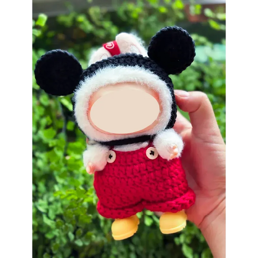 Hand holding a handmade doll wearing a Mickey inspired doll outfit with black ears and red shorts