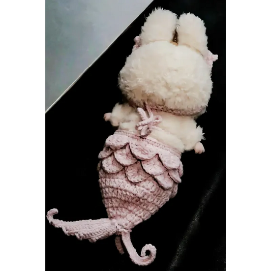 Soft plush bunny with a pink mermaid crochet doll pattern tail lying on black surface