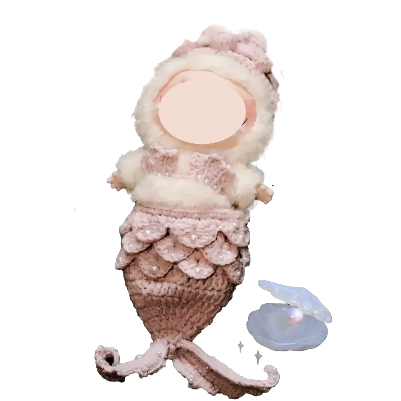 Handmade mermaid crochet doll with pink and white yarn details and a pearl inside a shell nearby mermaid crochet doll pattern