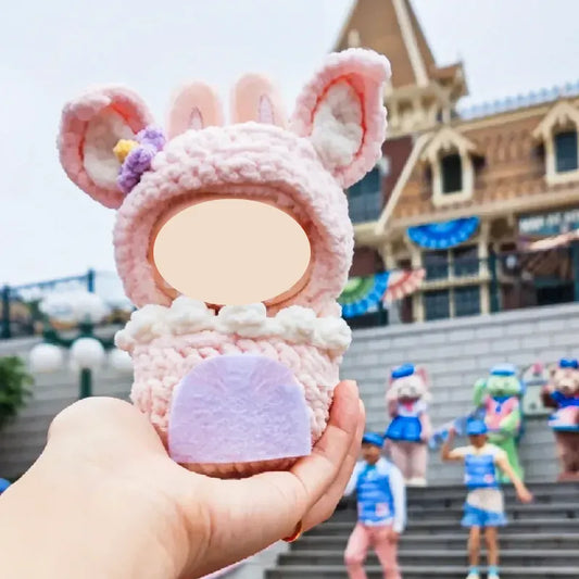 Hand holding cupcake doll pouch crochet pattern 17cm in pink with bunny ears and decorative details